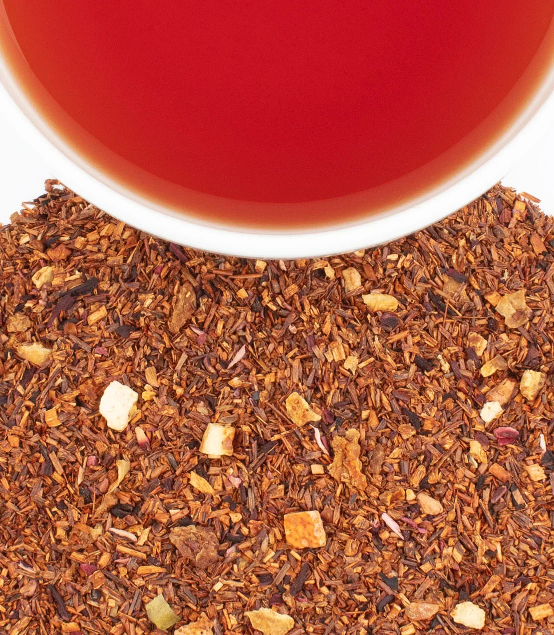 Cup of brewed African Autumn herbal tea with loose rooibos and fruit pieces
