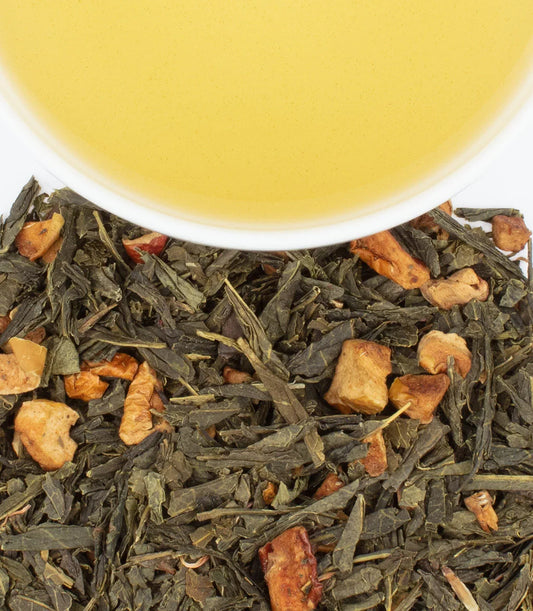 Cup of green tea with loose leaf and dried fruit pieces on white background