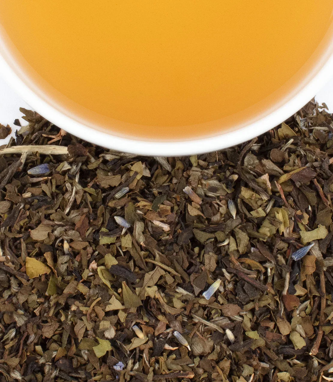 Cup of herbal Provence tea with loose leaf blend on a white surface