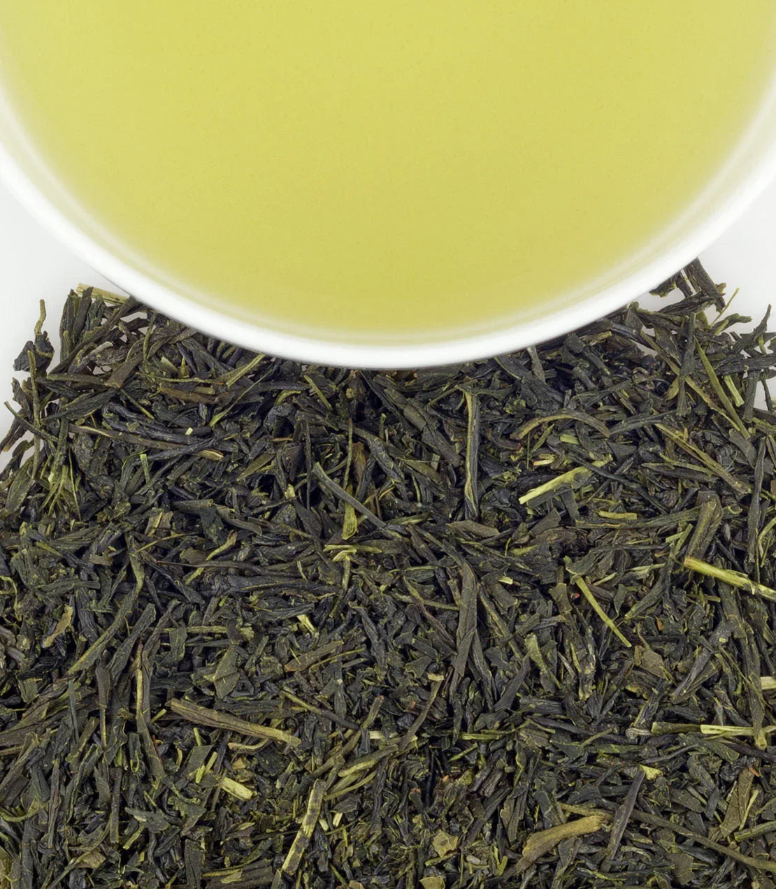 Japanese Sencha green tea in white cup with loose leaf tea on white background