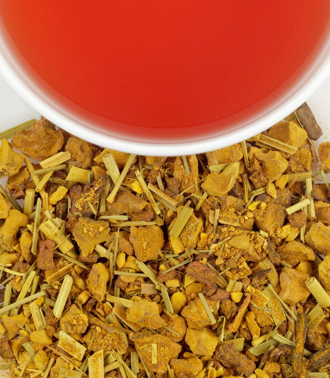 Organic ginger turmeric tea in white cup with loose herbal tea blend