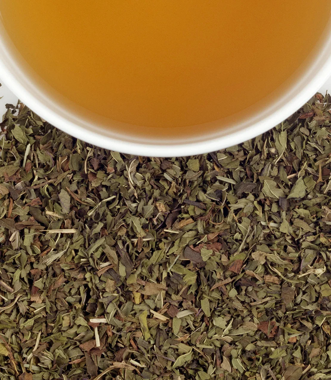 Cup of peppermint herbal tea with loose dried peppermint leaves