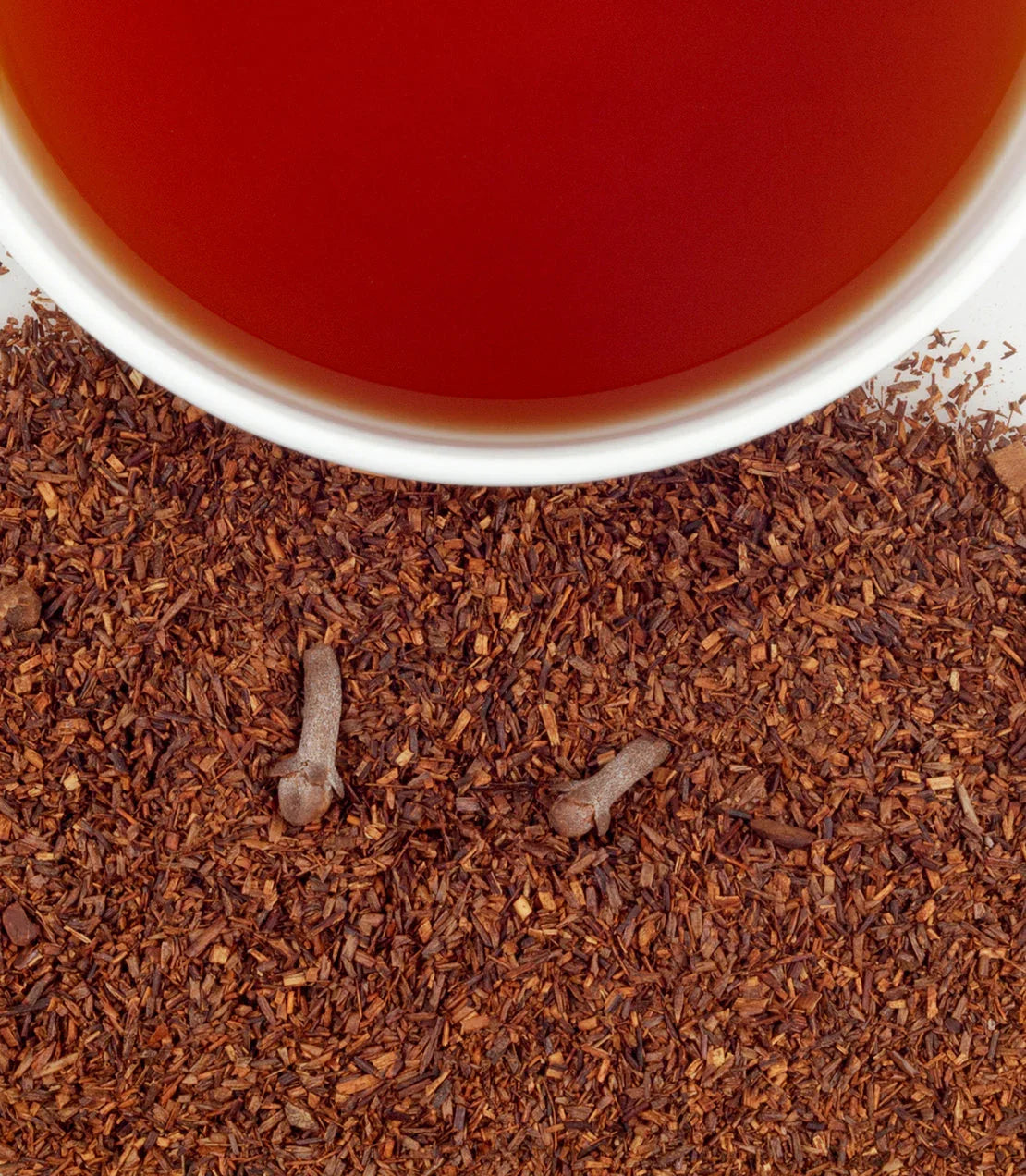 Harney & Sons Pumpkin Spice Tea Tin at Blinks Emporium pumpkin spice tea in white cup with loose rooibos and cloves on a white background