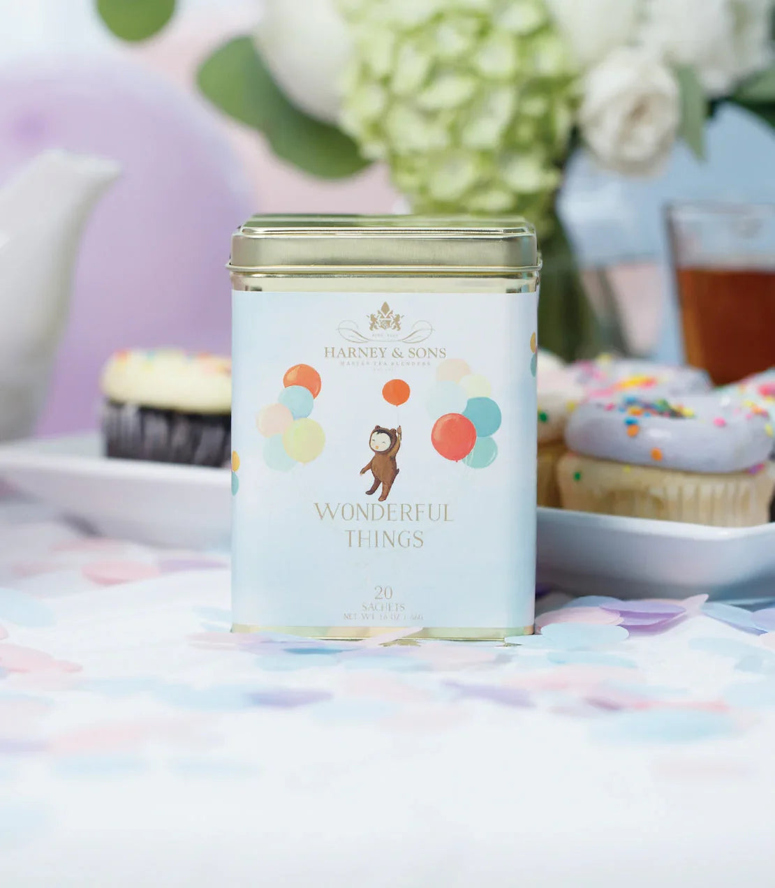 Harney & Sons Wonderful Things tea tin with balloons and cupcakes on a festive table