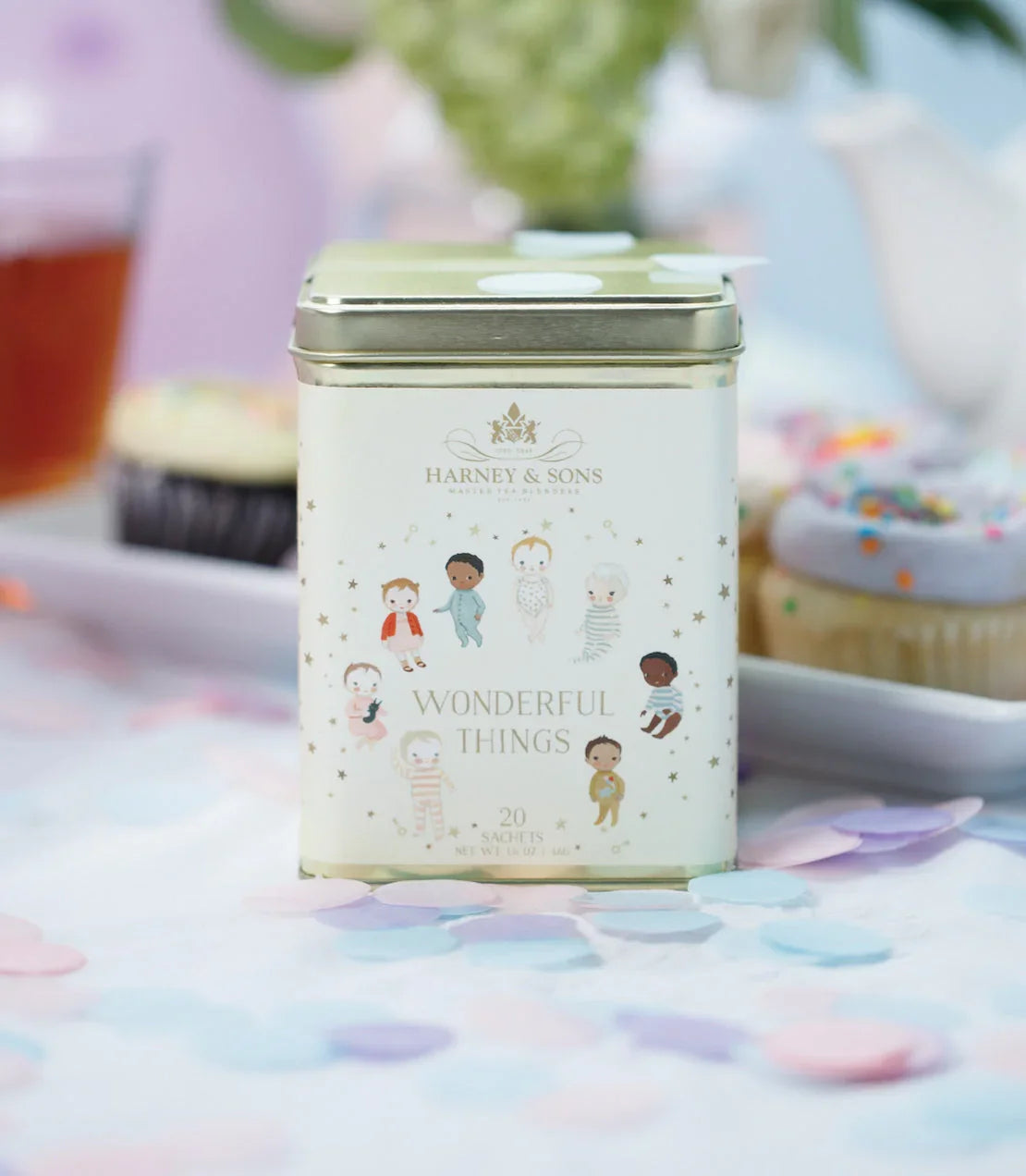 Harney & Sons Wonderful Things tea tin with 20 sachets on pastel confetti table, cupcakes in background