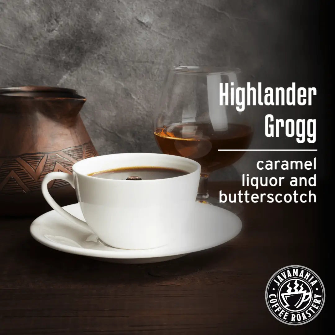 White cup of coffee on a saucer with a glass of Highlander Grogg in the background, featuring the Avamania Coffee Roaster logo.