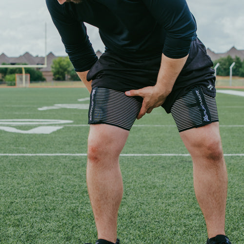 Person wearing black athletic shorts on a sports field - blinks emporium