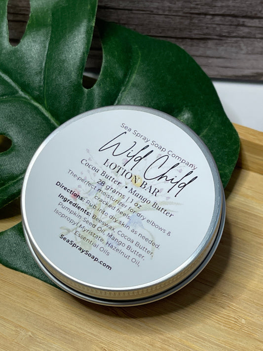 Lotion bar packaging with 'Wild Child' branding on a leaf and wooden surface